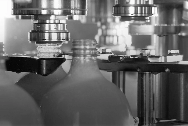 Black and white photo of bottling filler parts from FBN in action.