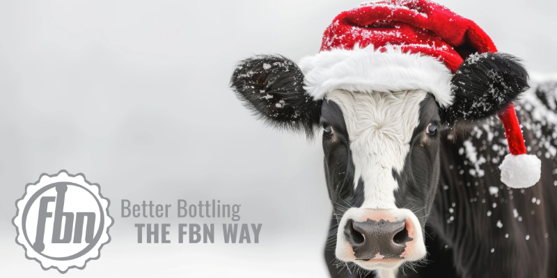 A cow with a Santa hat on out in the snow, with the logo of FBN Sales, Inc. in the bottom left corner.
